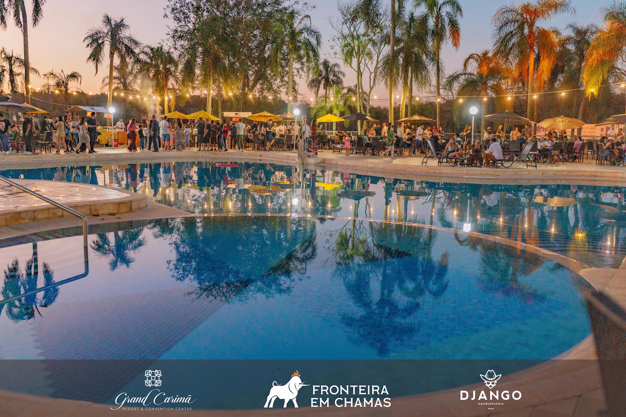Pátio da Piscina do Grand Carimã Resort, iluminado por um varal de luzes durante o Fronteira em Chamas